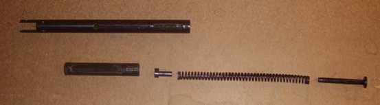 Disassembled piston, spring, and trigger pin laid out